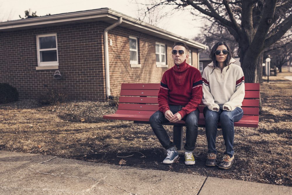 Woman & man waiting at bus bench