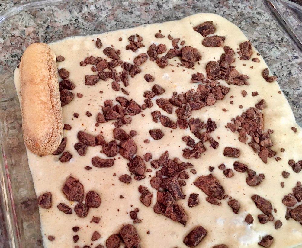 Photo of first layer of tiramisu. Finish the first layer by sprinkling half of the chunked chocolate over it. Then do everything the same for the second layer.