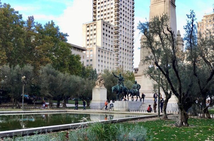 da-AL stands beside statues of Don Quixote and Sancho Panza at park in Madrid