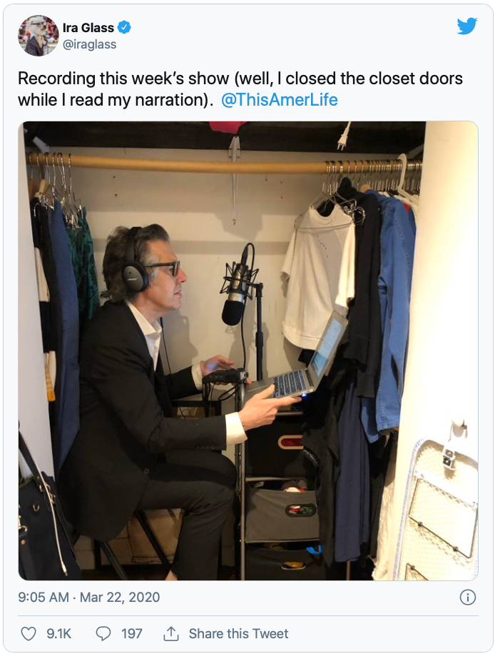 Photo of Ira Glass recording an episode of his radio show, "This American Life," in his small closet.