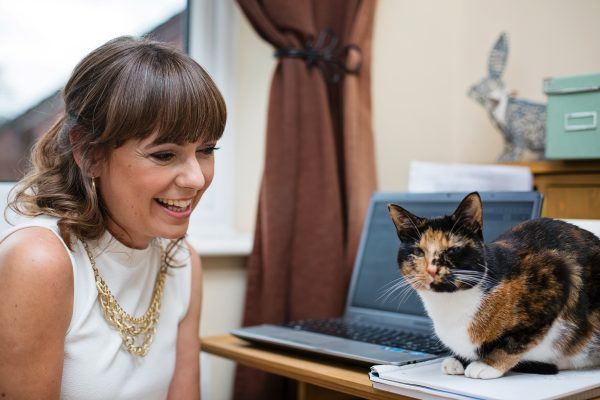 Photo of writer/blogger/editor/tutor/cat-fancier Esther Chilton Esther Chilton and her multi-colored tortoiseshell cat at her desk.