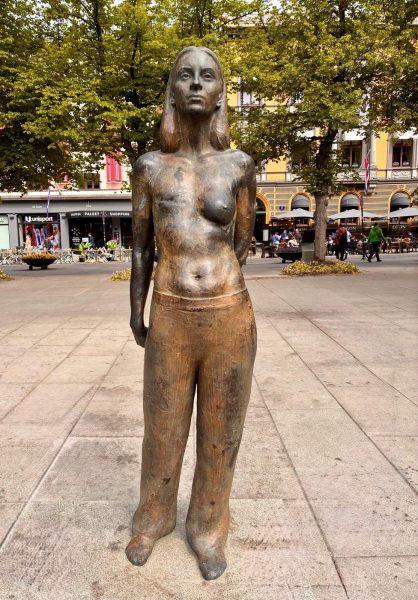 Sculpture of a young woman with a mastectomy scar.