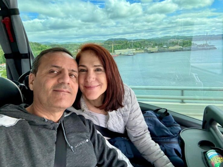 Photo of Khashayar and da-AL on bus from Oslo, Norway, to Kristiansand. Fjord and green loveliness behind them.