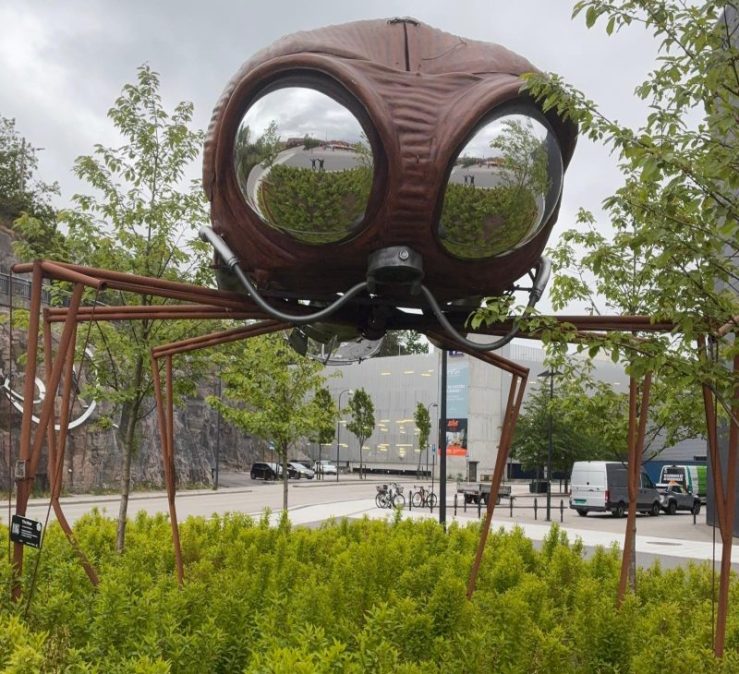 Photo of Khashayar and da-AL reflected in eyes of huge sculpture of a bug in Kristiansand, Norway.