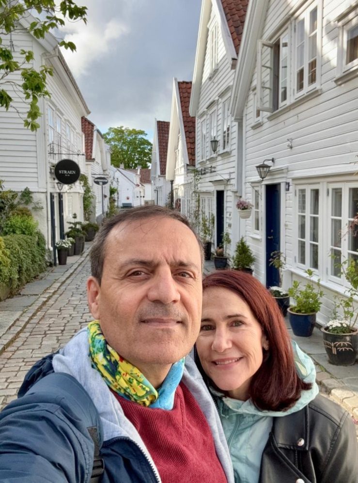 Khashayar and da-Al posing along a street of historic white buildings in Stavanger, Norway.